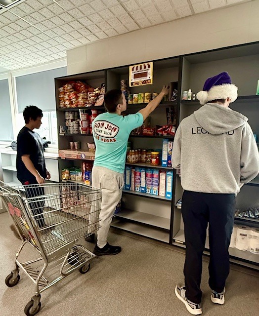 Students stocking shelves with food and hygiene products. 