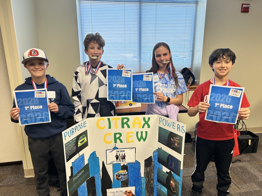 students proudly stand next to their design