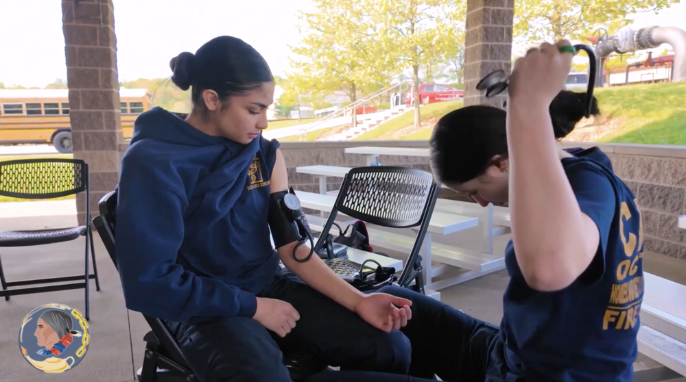 Two women work together to check blood pressure.
