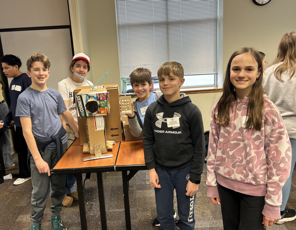 students proudly stand next to their design