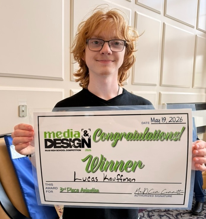 student holds sign that reads 'media & design competition, congratulations, third place winner"