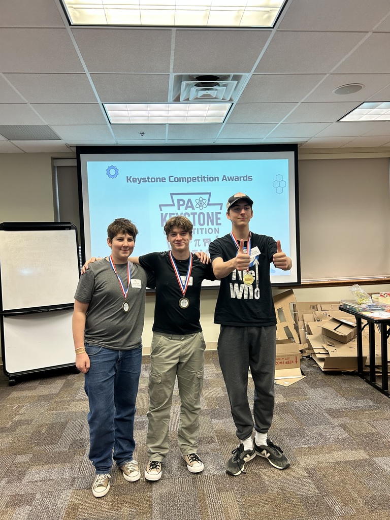 students proudly smile with their medal