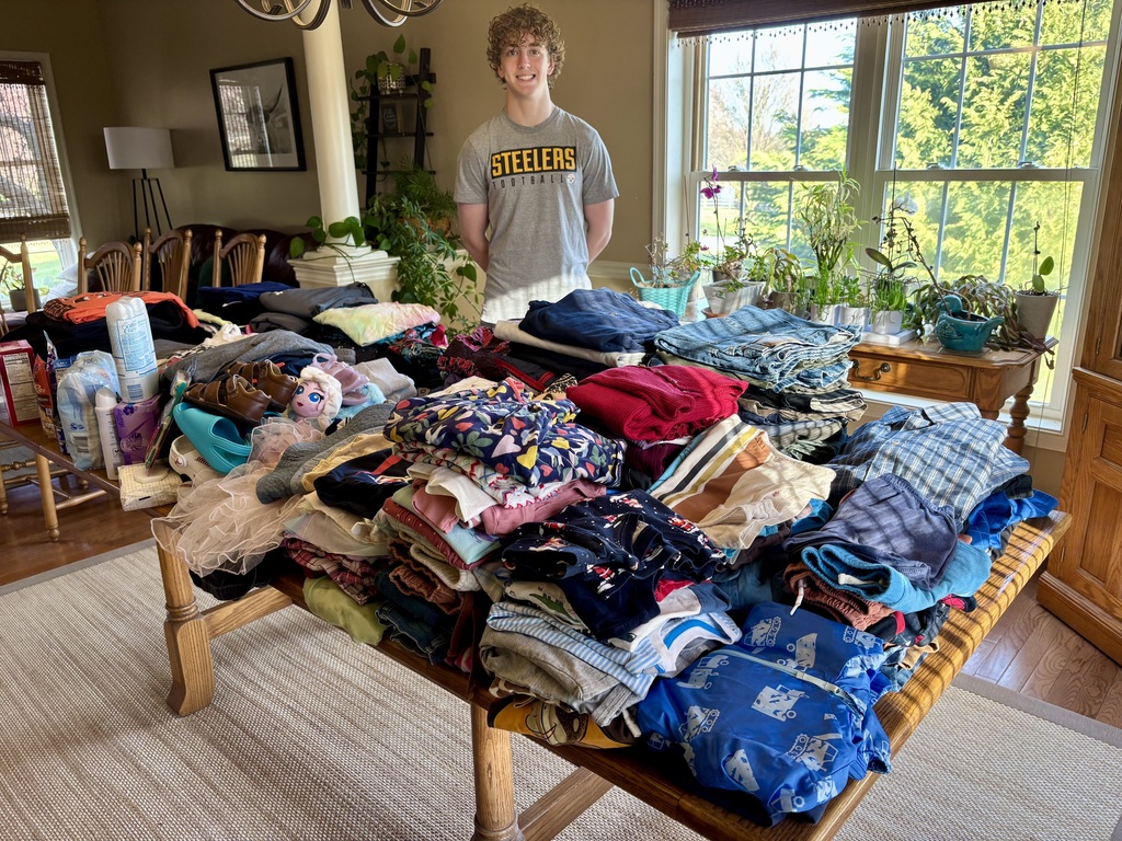 Student stands next to his donation drive for Brave Haven