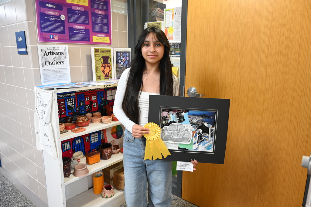 student stands with art piece 