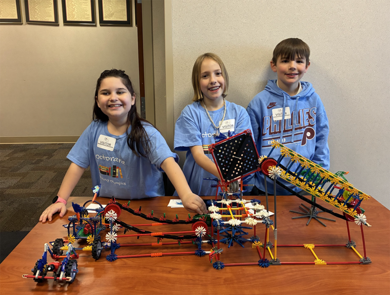 students proudly stand next to their design