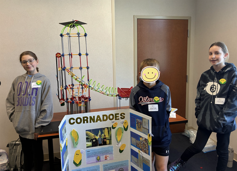 students proudly stand next to their design