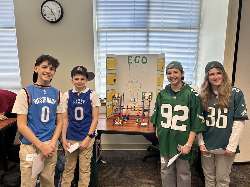 students proudly stand next to their design