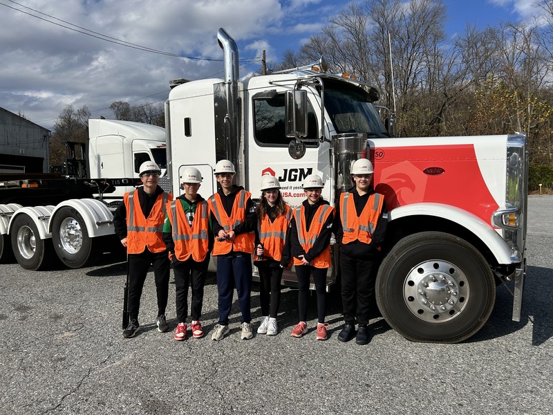 students stand in front of JGM truck in their hard hats