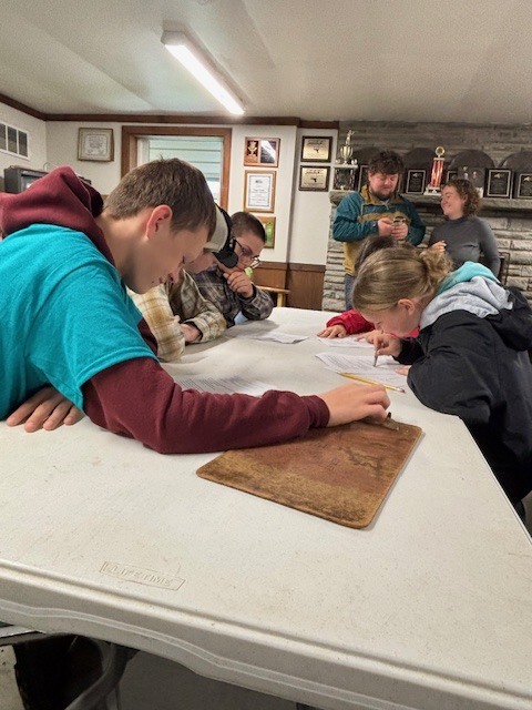 students working together at table with papers and pencils
