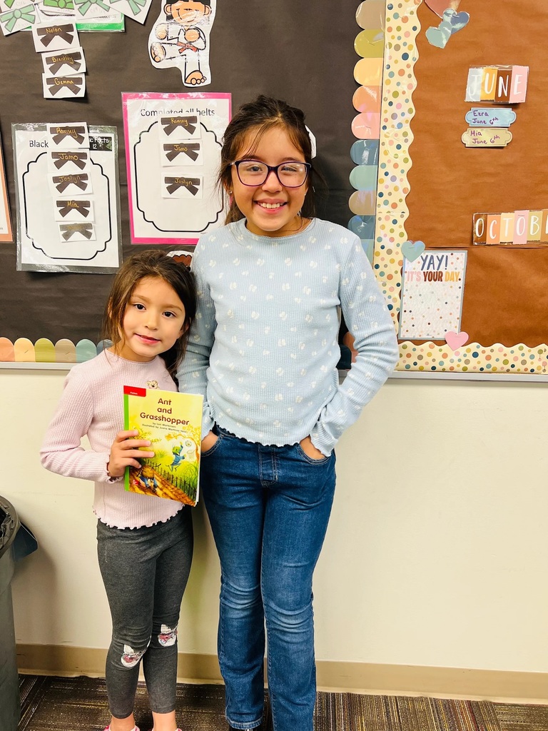 sisters standing together with a book