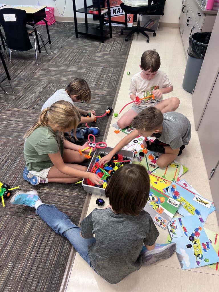 group of students building around a box of kinex pieces