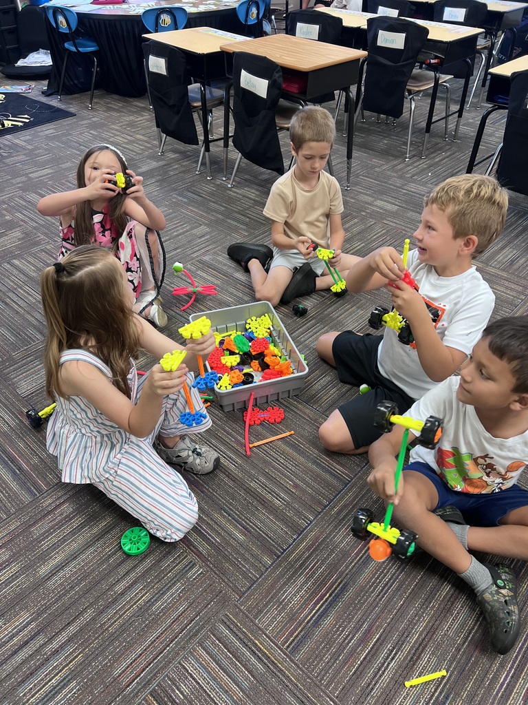 group of students building around a box of kinex pieces