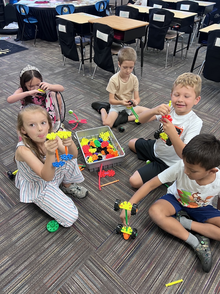 group of students building around a box of kinex pieces