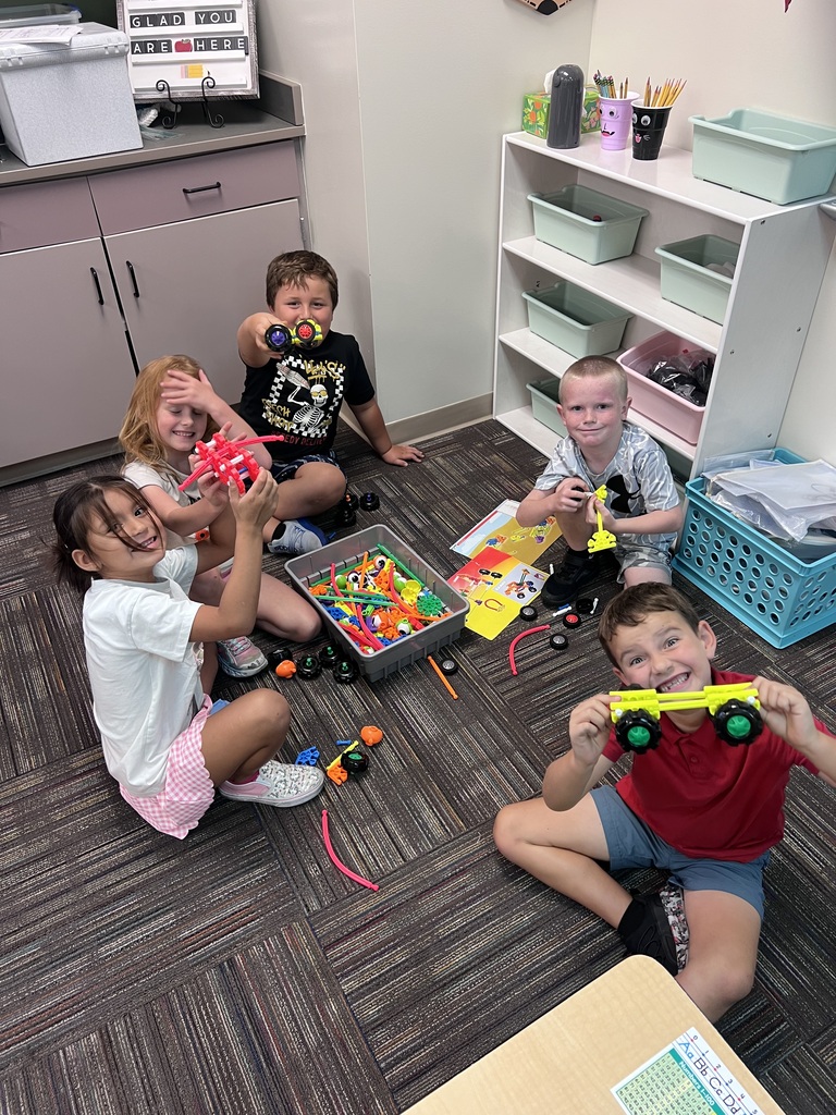 group of students building around a box of kinex pieces