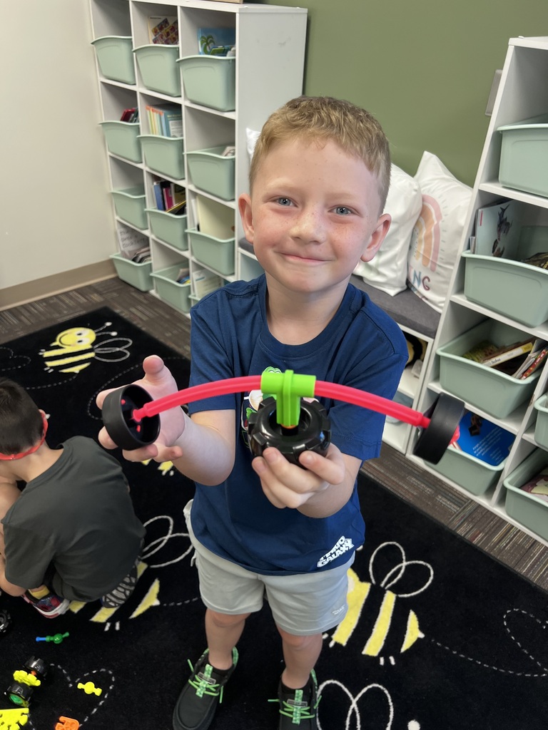 student holding kinex structure