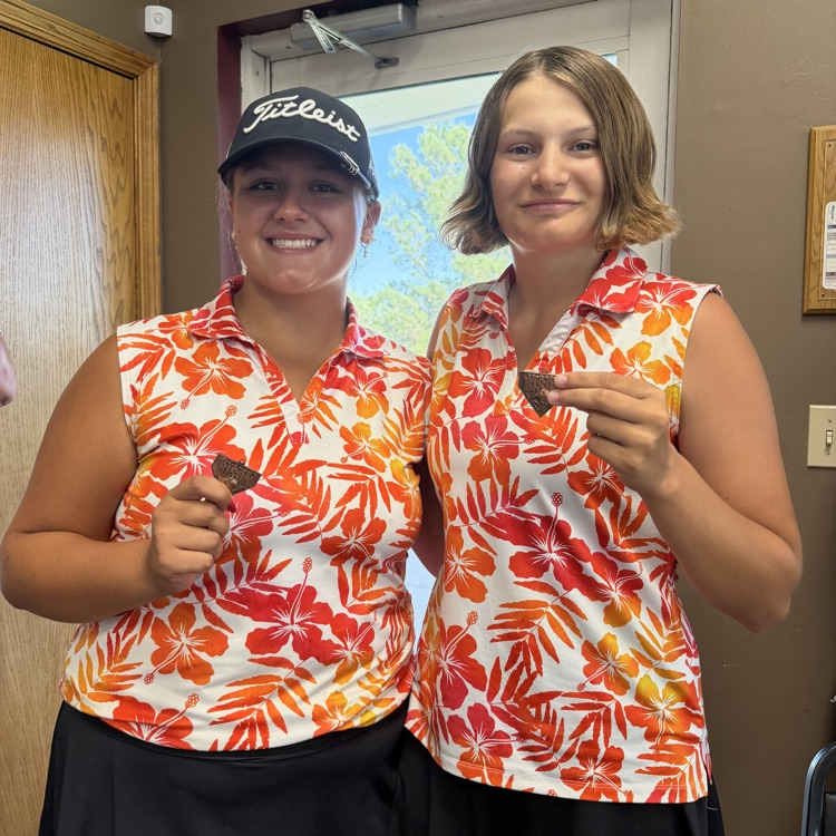 two golfers holding medals 