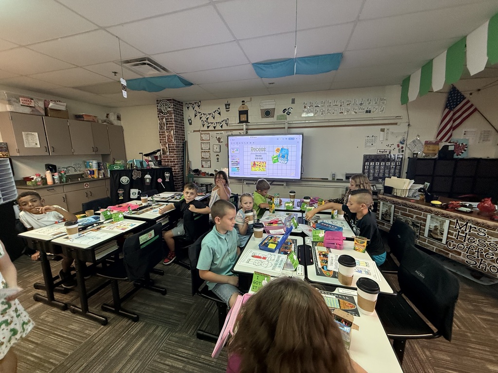 students sitting at desks in rows while drinking chocolate milk