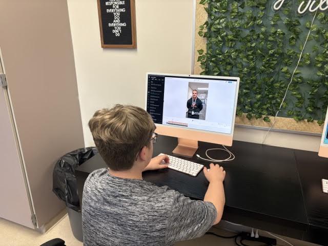 student looking at computer screen working on editing video