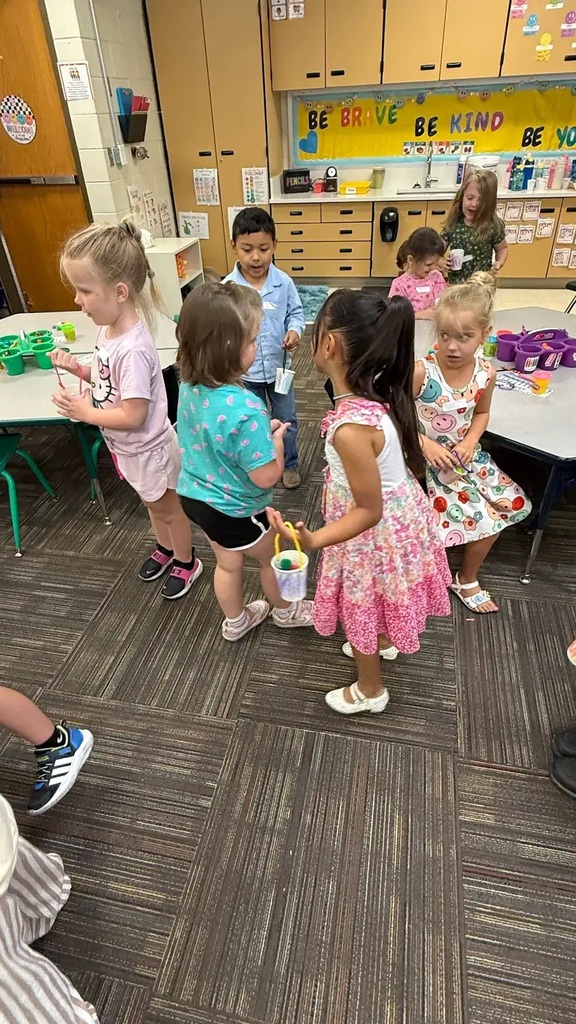 students holding buckets walking around a classroom