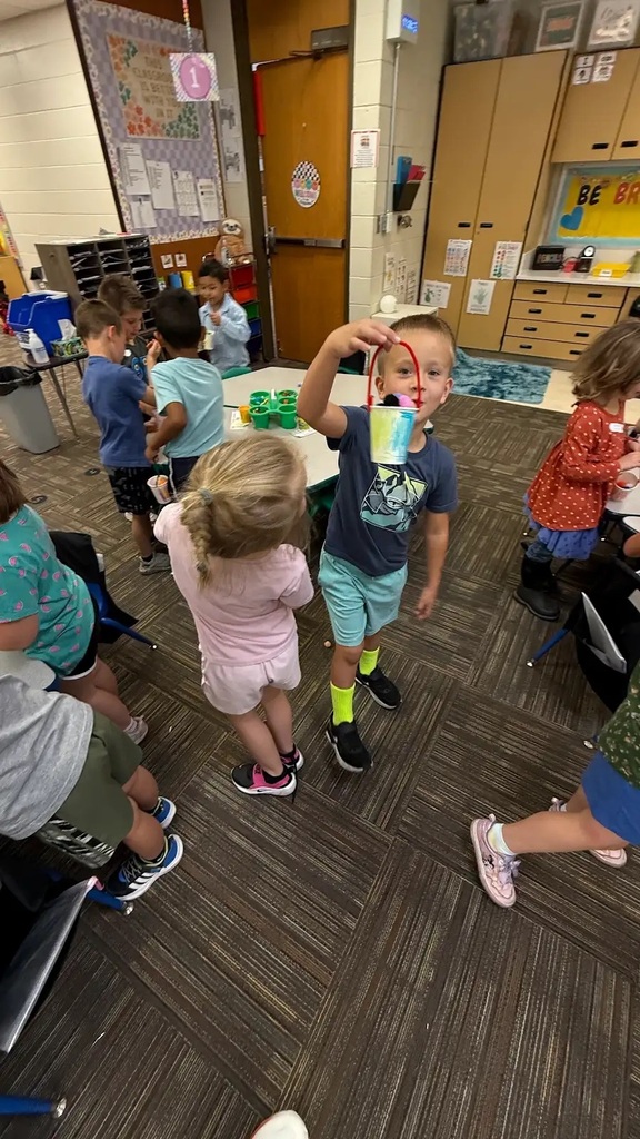 students holding buckets and walking around classroom