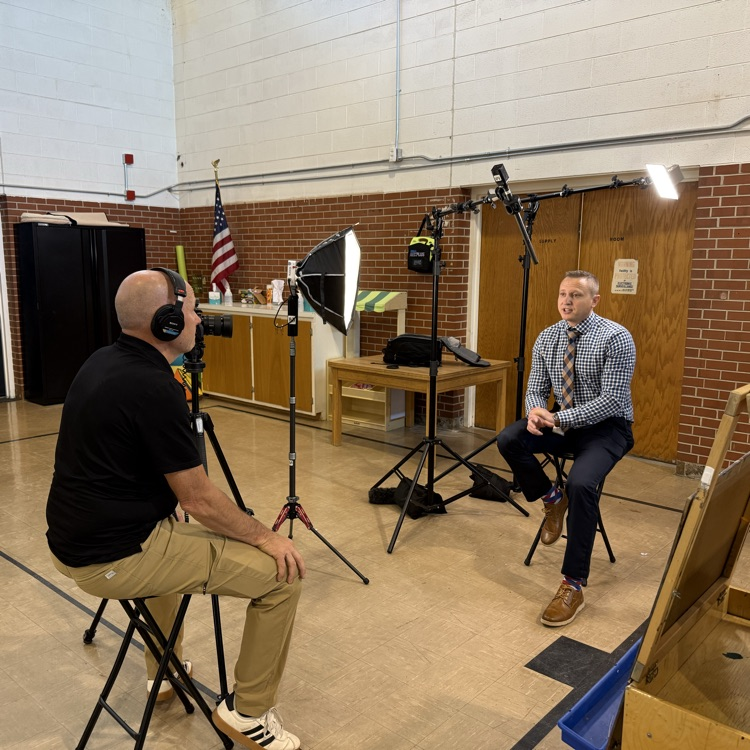 interview set up with two men sitting on stools