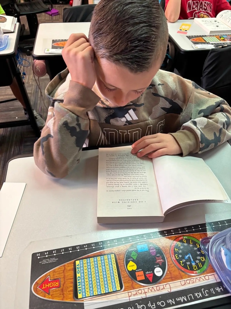 student siting at desk reading book
