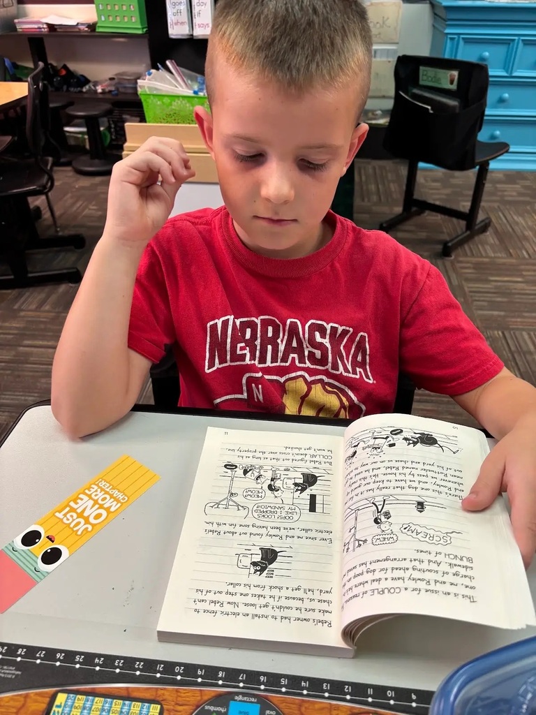 student siting at desk reading book