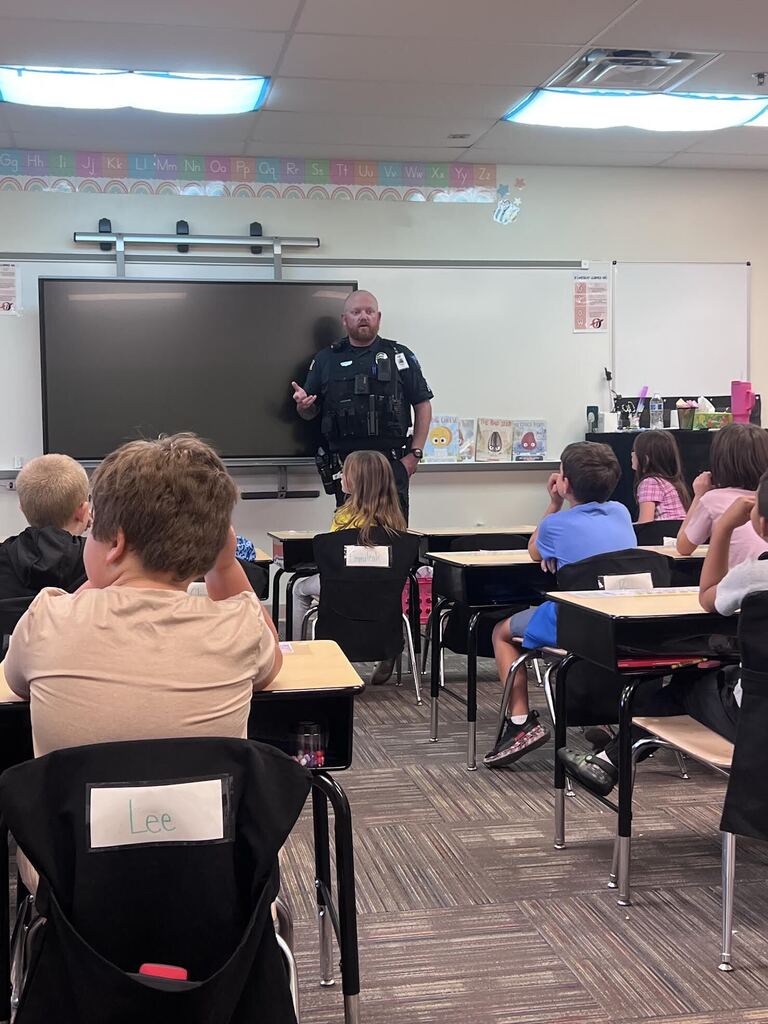 police officer standing in front of class of students