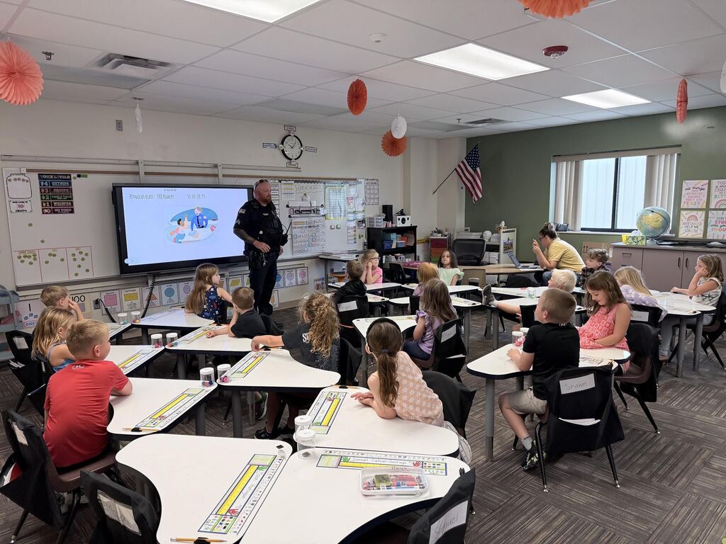 police officer standing in front of class of students