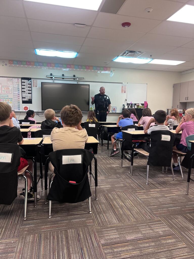 police officer standing in front of class of students