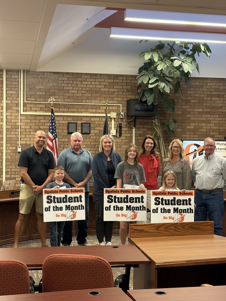 3 students standing in front of school board members 