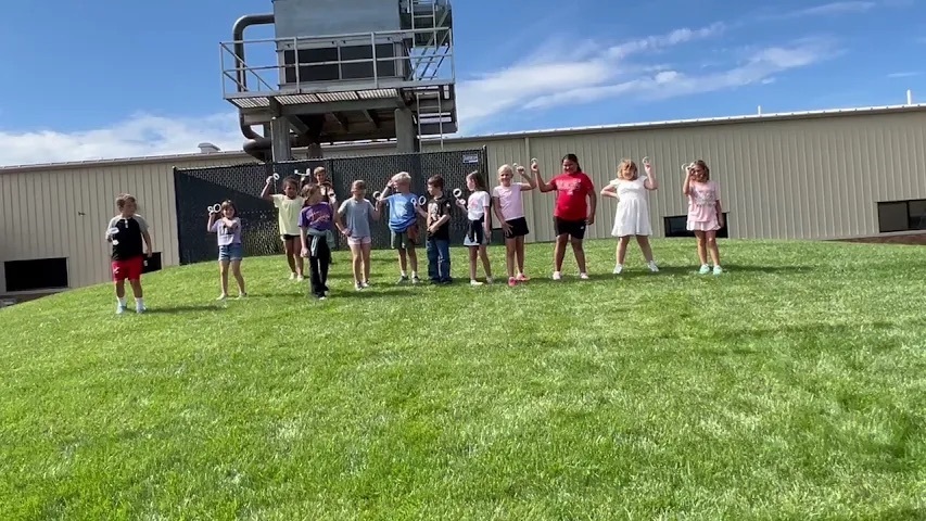 students standing in grass getting ready to throw homemade flyers 