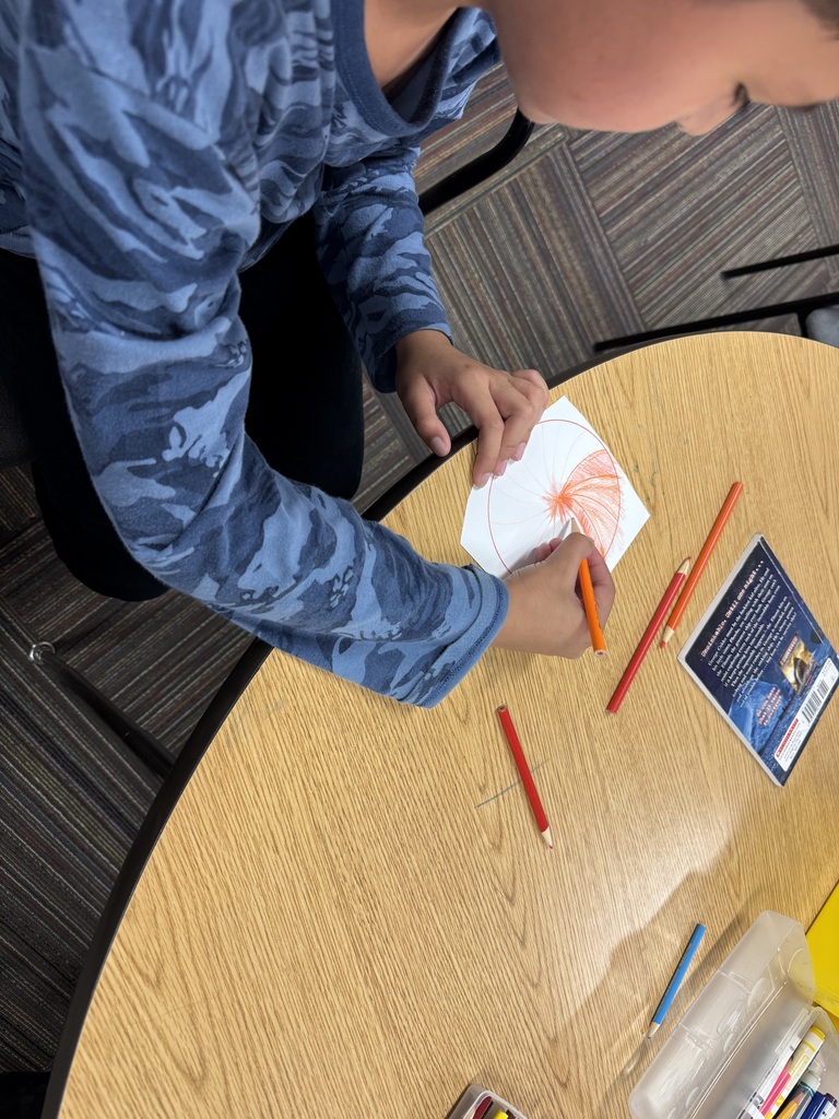 student shading a dot with orange and red colored pencils