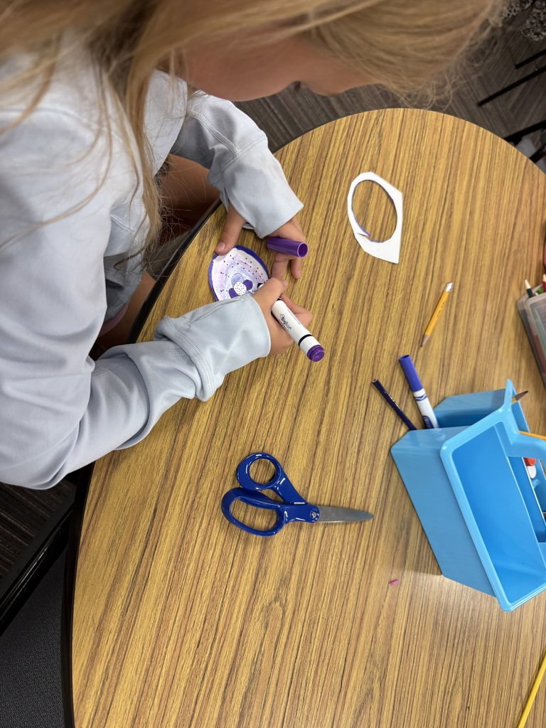 student coloring dot with a purple marker