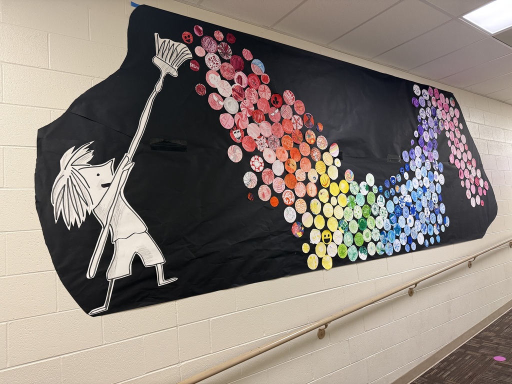 girl holding paint brush with a wave of colorful dots on a black paper