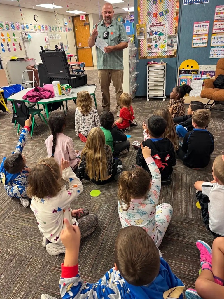 man standing in front of a group of children talking