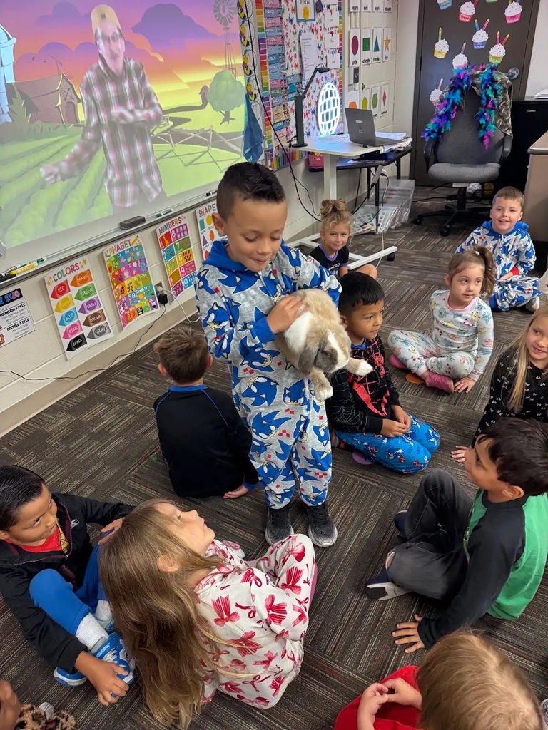 student holding his bunny walking through a group of kids