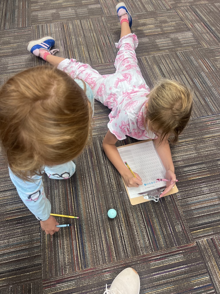 two students with a clipboard doing math