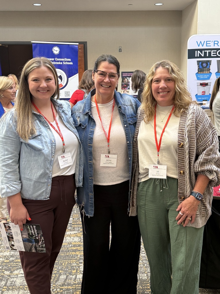 3 women standing at a conference smiling