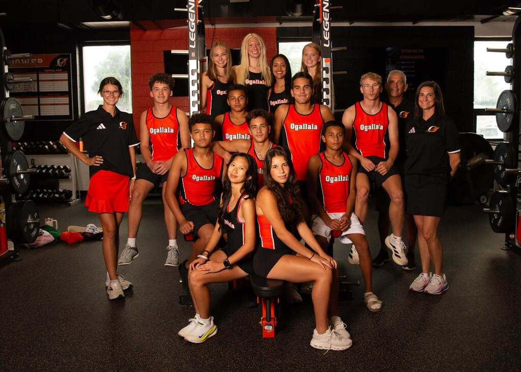 cross country team sitting on weight lifting equipment
