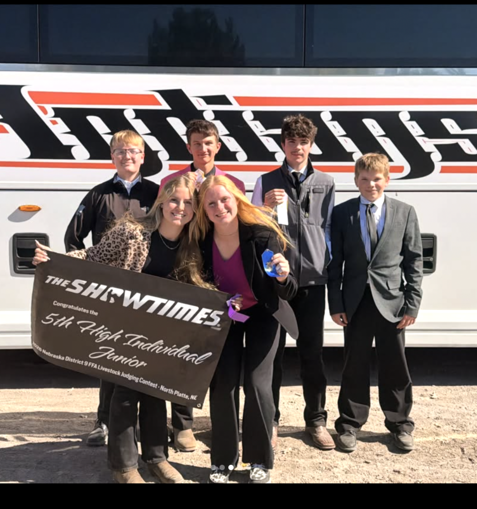 ffa students holding ribbons and sign standing in front of bus