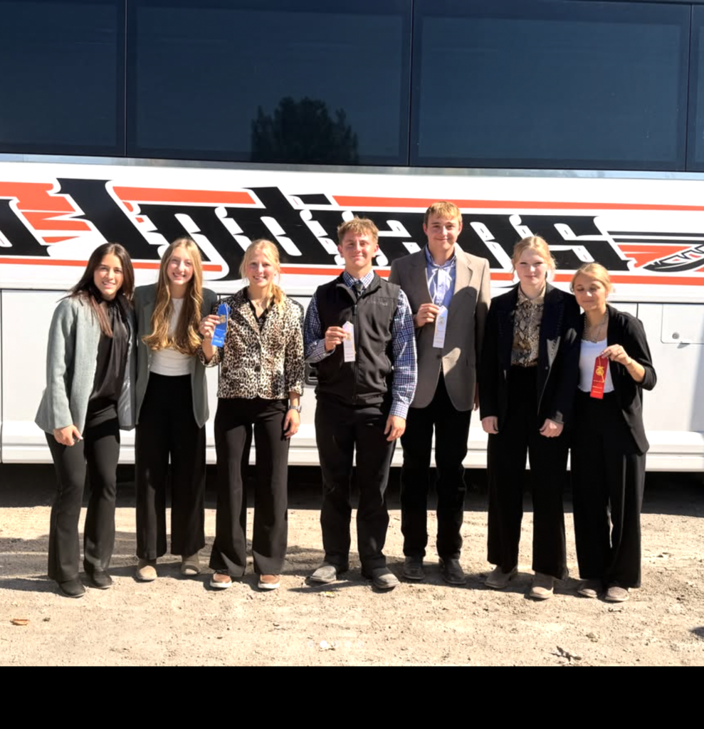 ffa students holding ribbons standing in front of bus