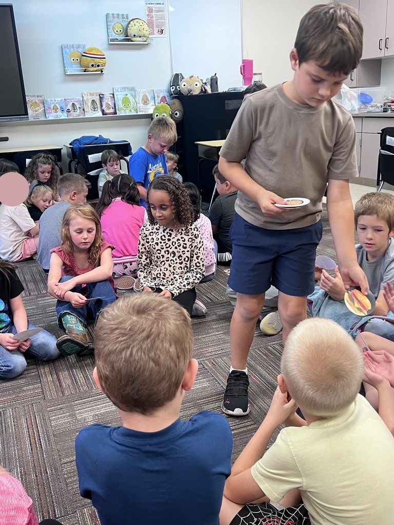students sitting in a circle on the carpet organizing dots