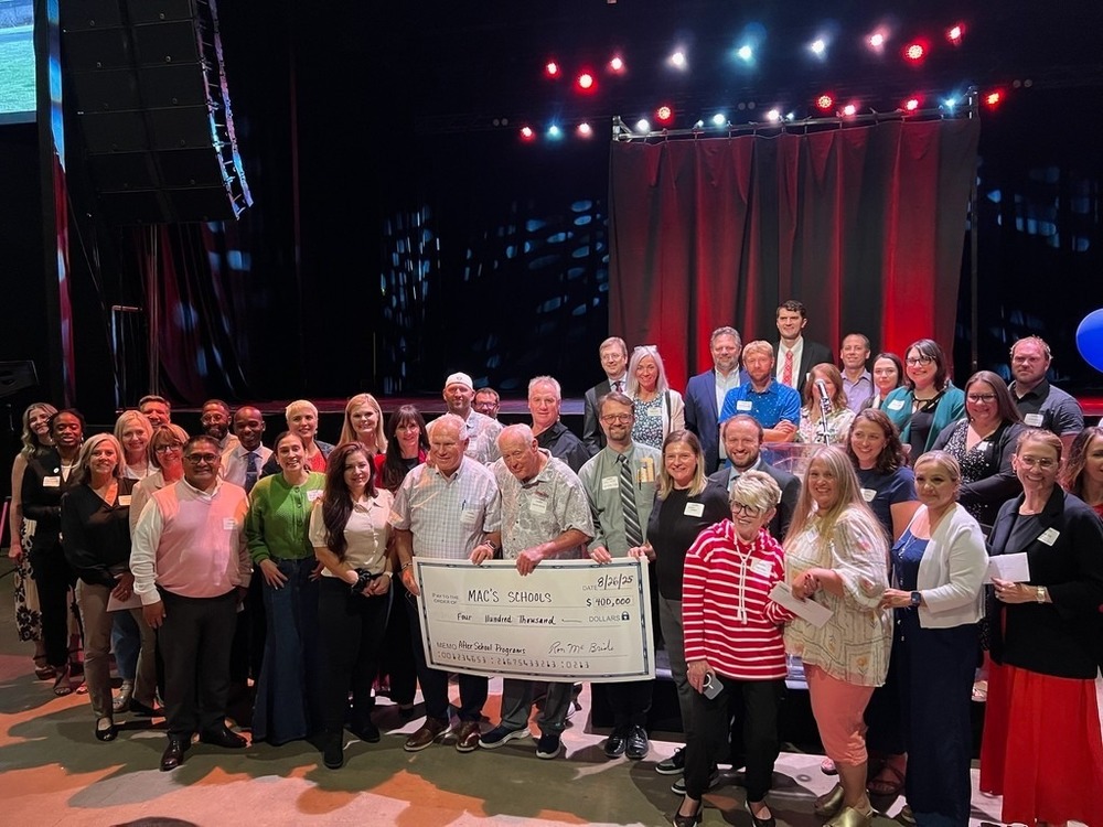 Ron McBride with giant check and principals from schools being awarded funds