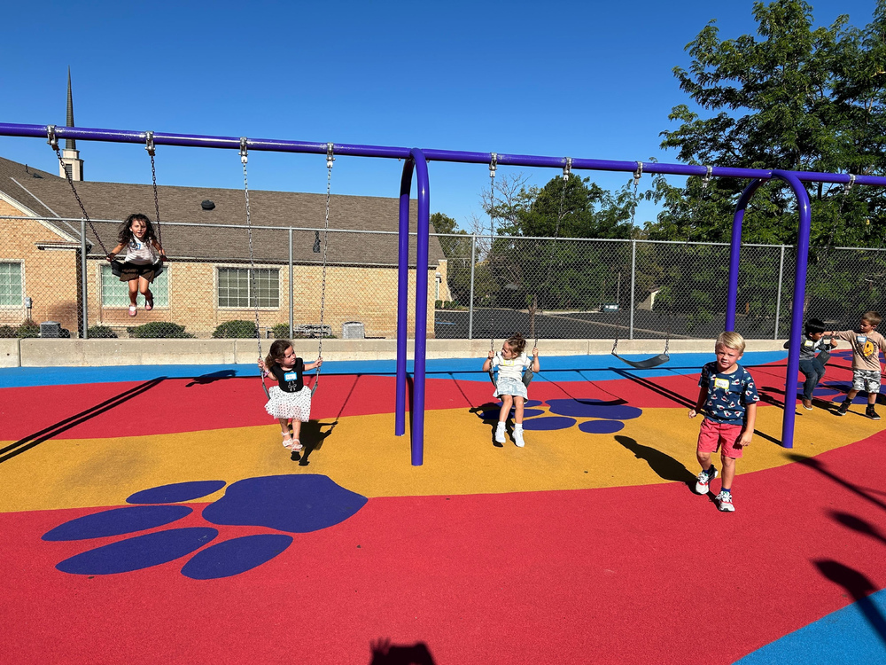 Kids swinging on swings on the playground outside