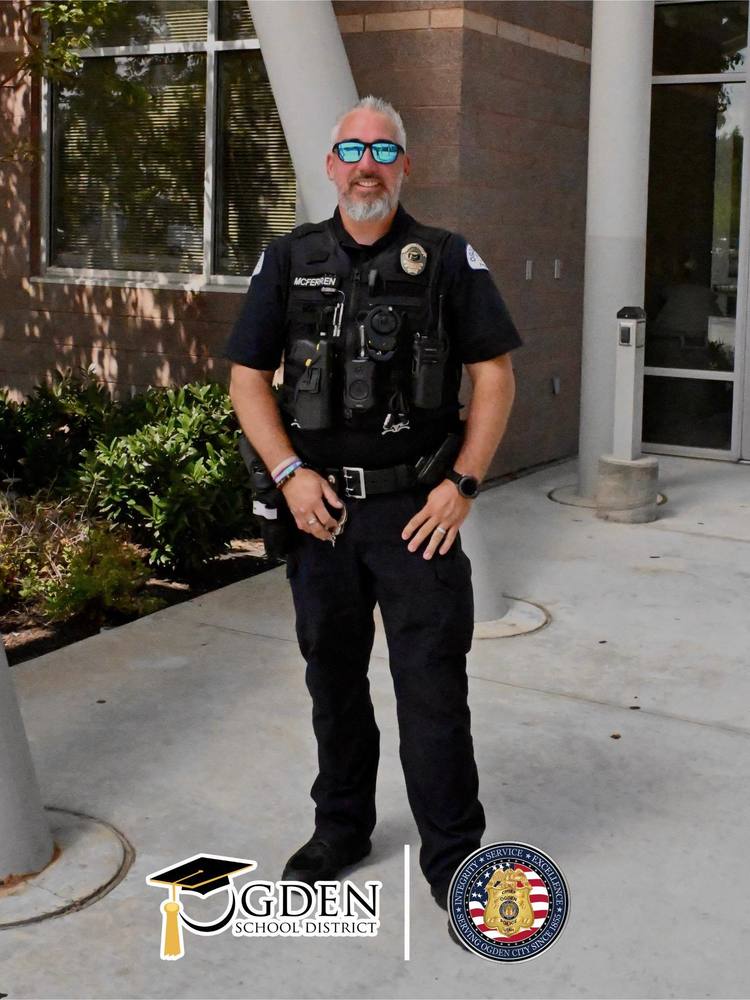 Ogden Police Officer stands near school entrance