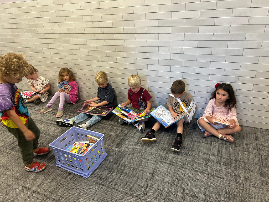 Kids sitting in the hallway reading books