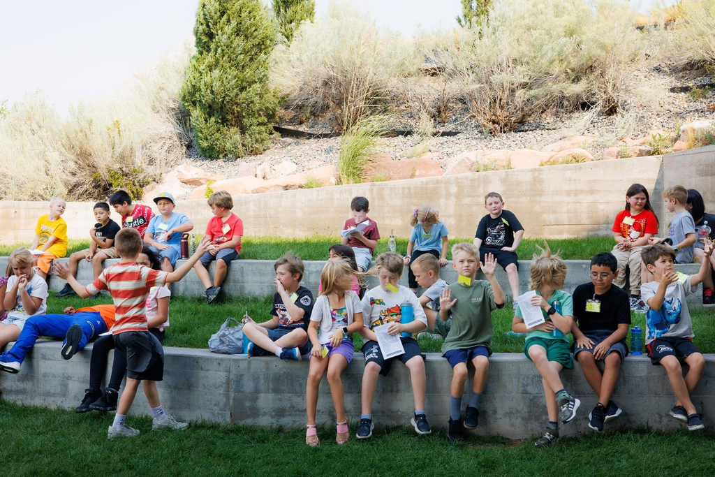 students sitting outside on a the lawn talking
