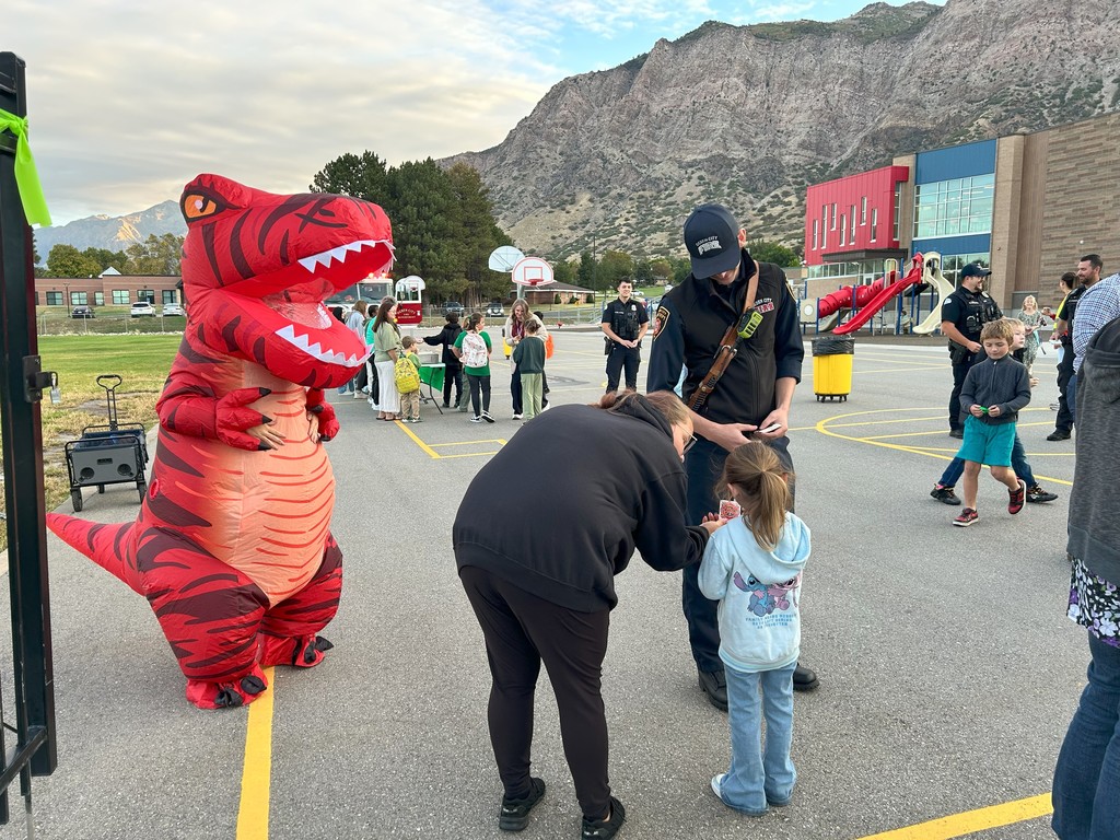 kid with police office and adult in raptor costume