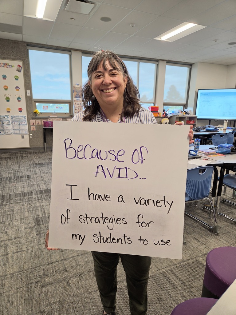 Teacher holding white board with the explanation of why they love AVID